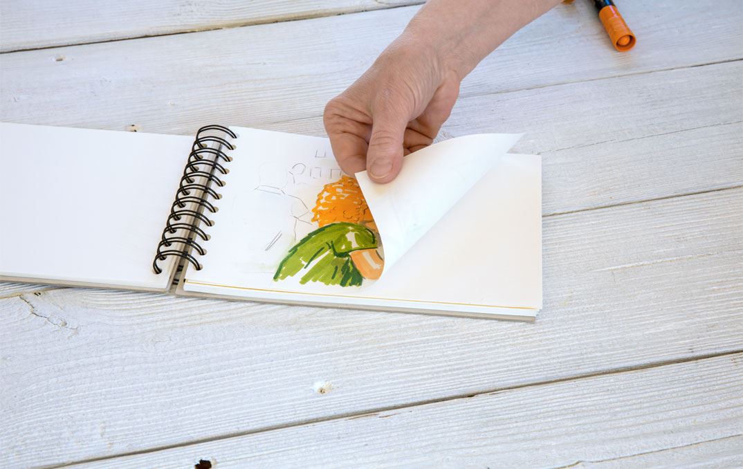 Hand leafing through a colouring book.